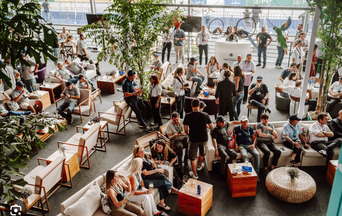Guests gathering and talking in a busy sports hospitality lounge
